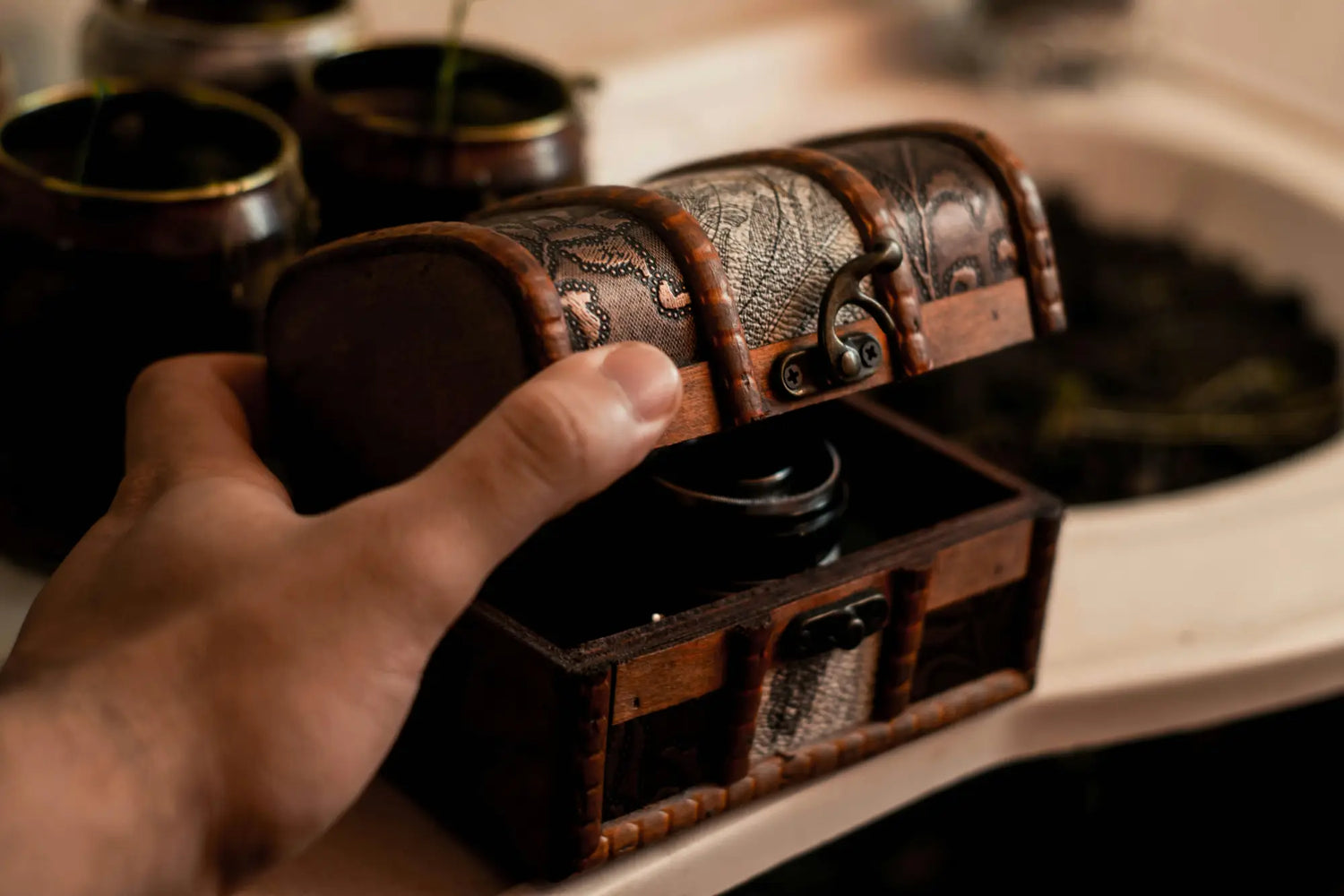 Hand opens vintage leather treasure chest from Honeybee Vintage Alton giftable goodies