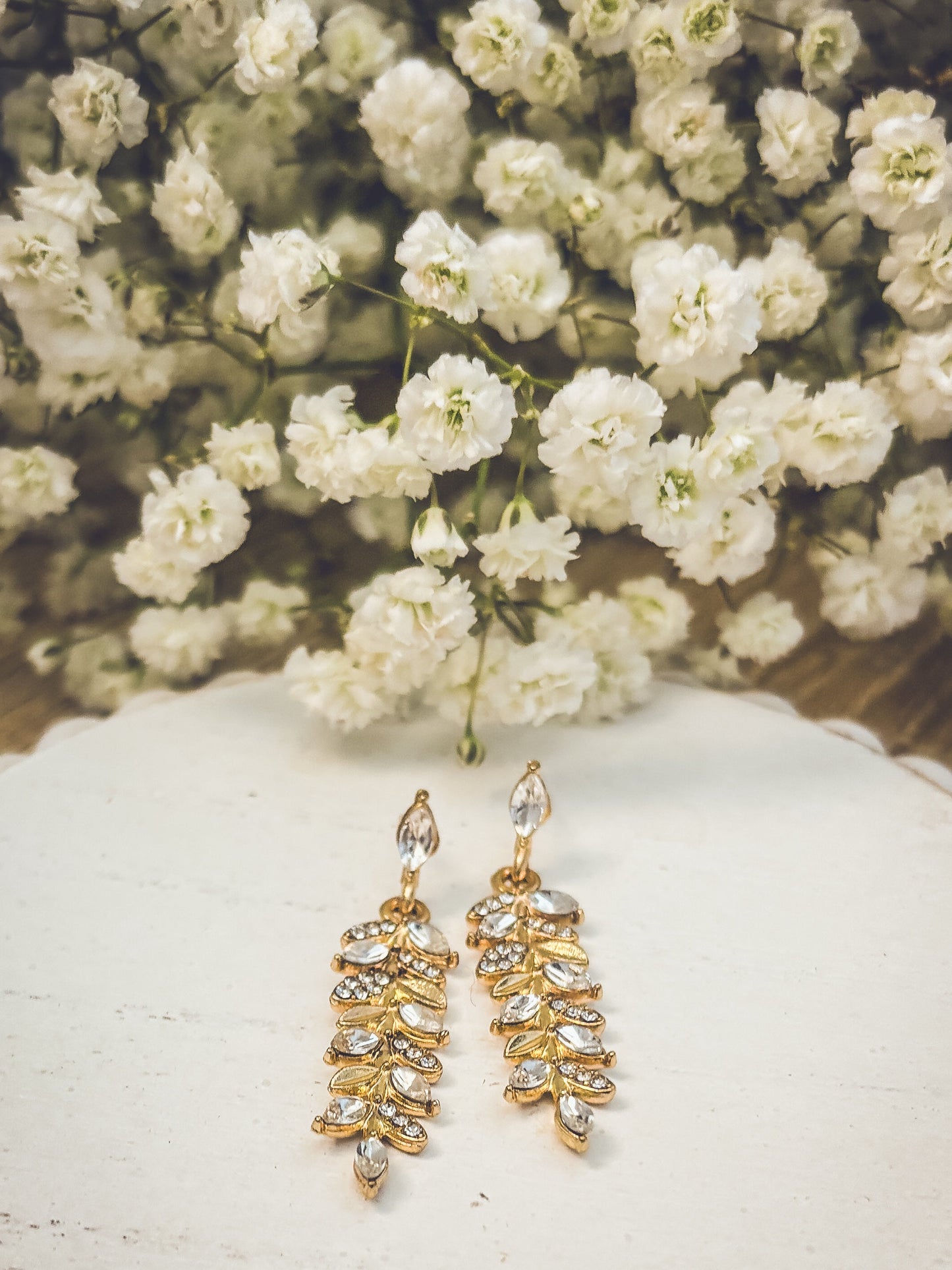 Hermosos aretes colgantes de hojas de oro y cristal