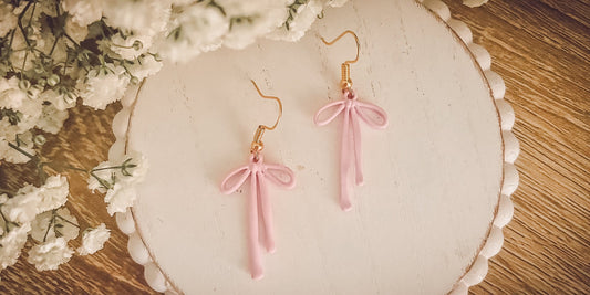 Boucles d'oreilles adorables avec un nœud rose 