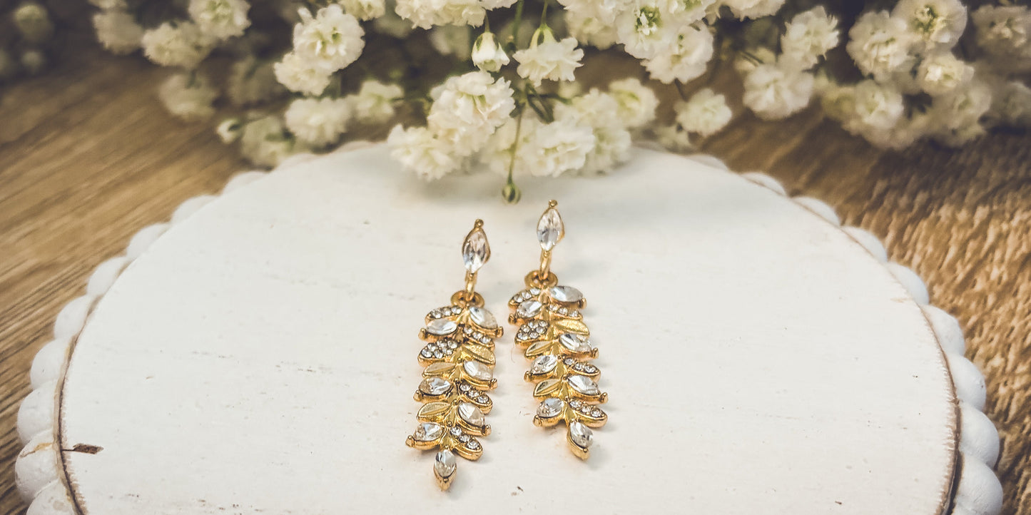 Hermosos aretes colgantes de hojas de oro y cristal